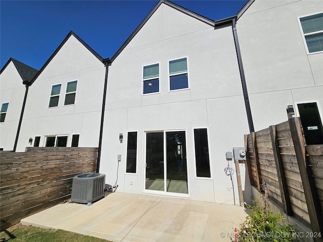 rear view of property with central air condition unit and a patio area