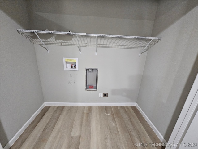 clothes washing area with light hardwood / wood-style flooring, washer hookup, and hookup for an electric dryer