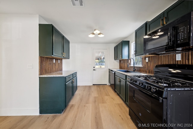 kitchen featuring light hardwood / wood-style flooring, black appliances, sink, and light stone counters