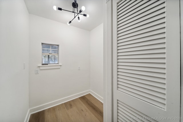 laundry room with an inviting chandelier and light hardwood / wood-style floors