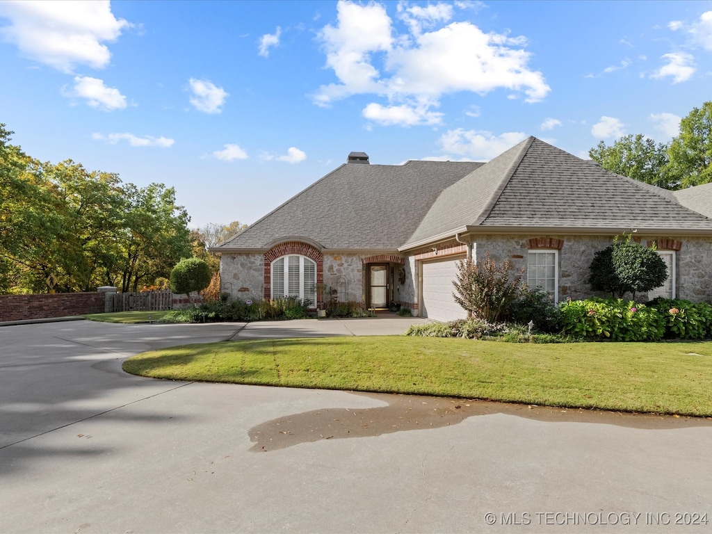 view of front of house featuring a front lawn and a garage