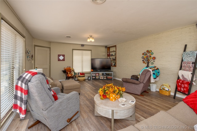 living room featuring brick wall and hardwood / wood-style floors