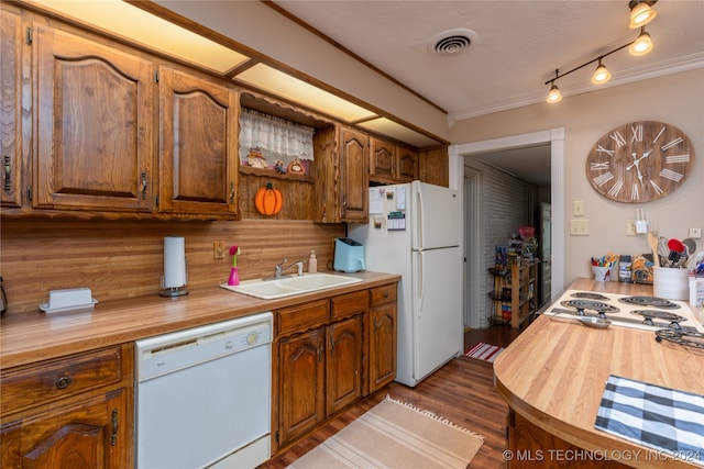 kitchen featuring decorative backsplash, ornamental molding, dark wood-type flooring, sink, and white appliances