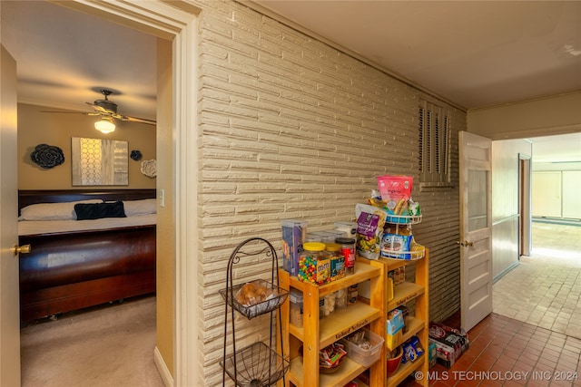 playroom featuring ceiling fan, brick wall, ornamental molding, and tile patterned flooring