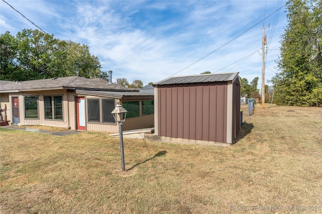 back of property with a shed and a lawn