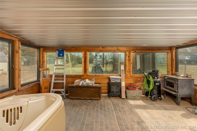 sunroom / solarium featuring a wood stove and a wealth of natural light