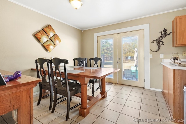 tiled dining room featuring ornamental molding and french doors