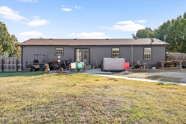 back of property featuring a yard, a patio area, french doors, and a jacuzzi