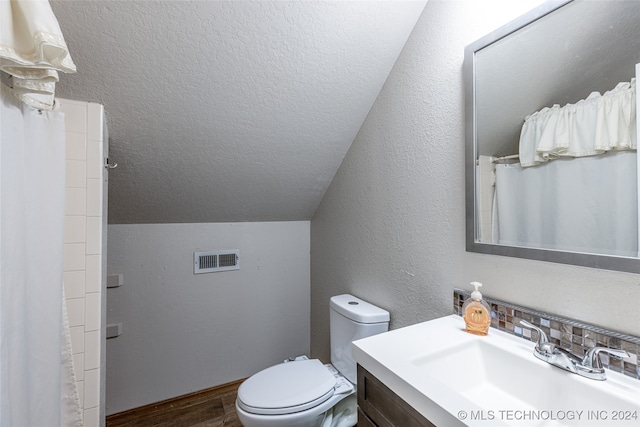 bathroom featuring a shower with curtain, vanity, hardwood / wood-style flooring, toilet, and lofted ceiling