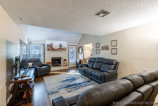 living room with dark hardwood / wood-style flooring, lofted ceiling, a textured ceiling, and a fireplace