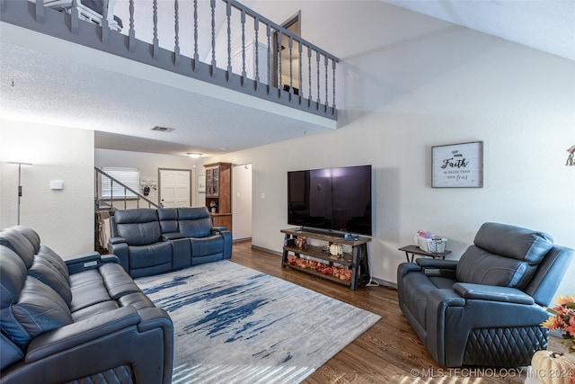 living room featuring dark wood-type flooring and a textured ceiling