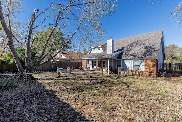 rear view of house featuring a lawn