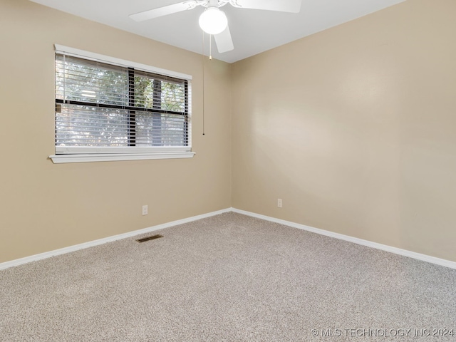 carpeted spare room with ceiling fan