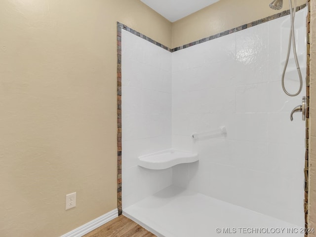 bathroom featuring tiled shower and wood-type flooring