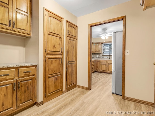 hallway featuring sink and light hardwood / wood-style flooring