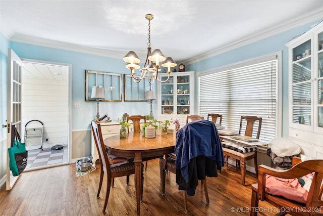 dining space featuring crown molding, hardwood / wood-style flooring, and a chandelier