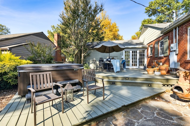 deck with a hot tub and french doors