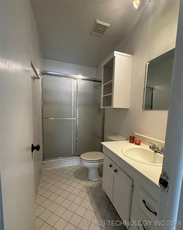 bathroom with vanity, an enclosed shower, toilet, and tile patterned floors