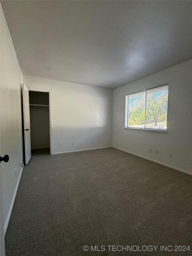 empty room with dark colored carpet