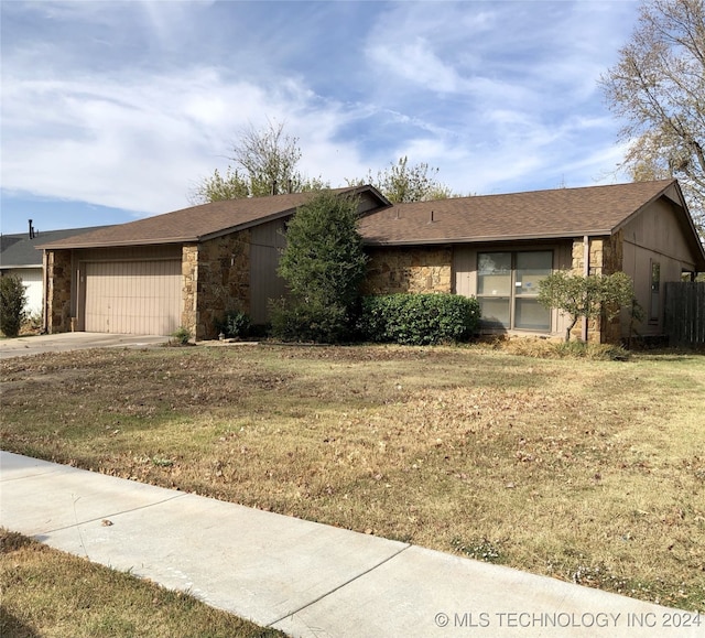 ranch-style house featuring a garage and a front yard