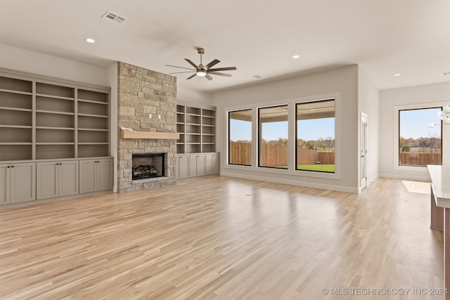 unfurnished living room with ceiling fan, light wood-type flooring, and a fireplace