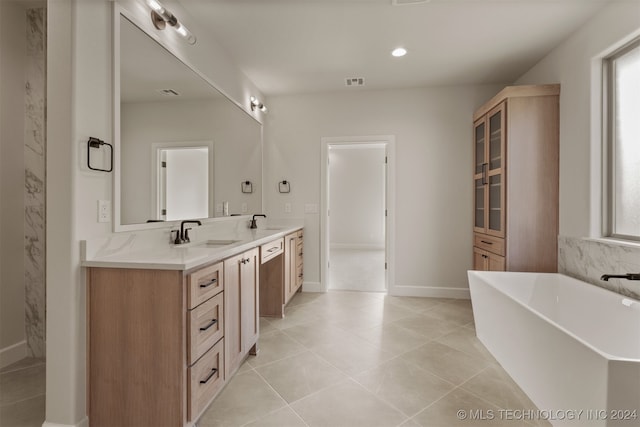 bathroom featuring vanity, a tub to relax in, and tile patterned flooring