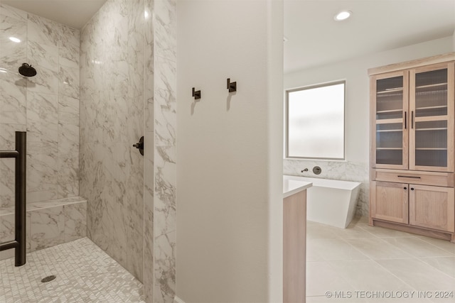 bathroom with independent shower and bath and tile patterned flooring