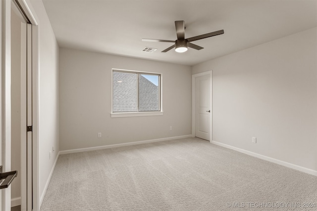 carpeted spare room with ceiling fan