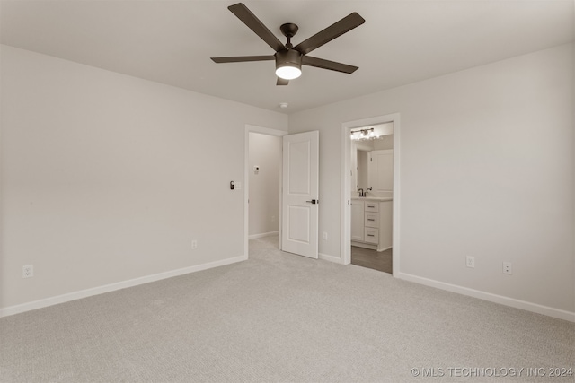 unfurnished bedroom featuring light carpet, ensuite bathroom, and ceiling fan