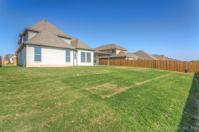 rear view of house featuring a lawn