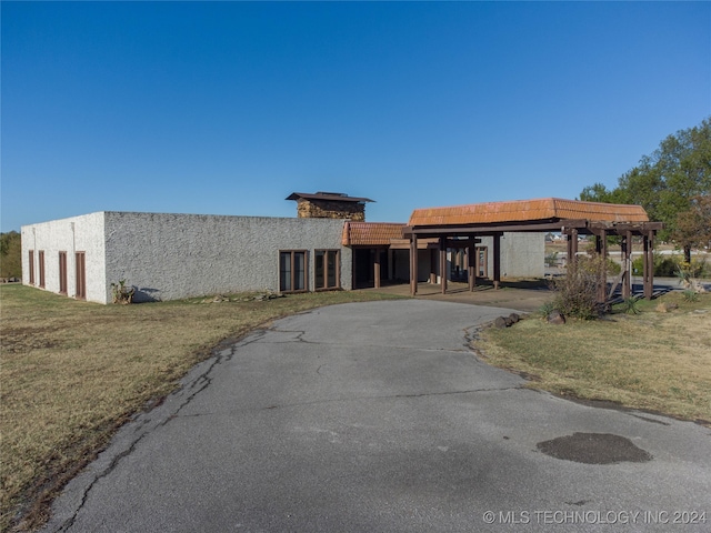 view of front of property featuring a carport and a front lawn