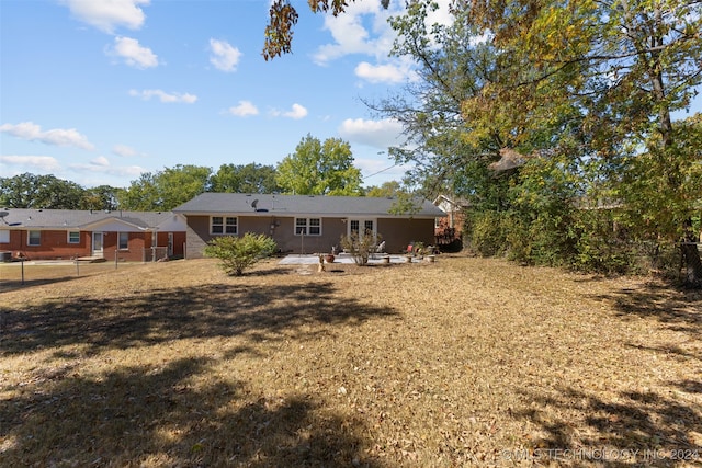 back of property with a yard and a patio area