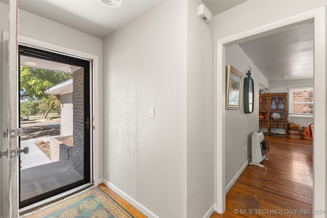 foyer entrance with heating unit, a healthy amount of sunlight, and dark hardwood / wood-style flooring