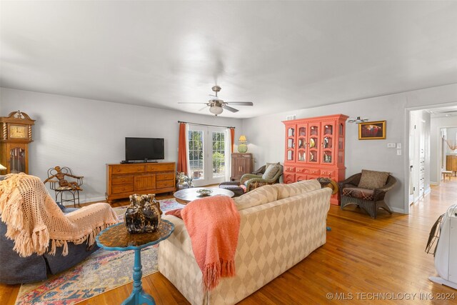 living room with light hardwood / wood-style floors and ceiling fan