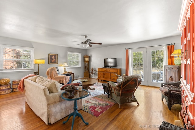 living room with light hardwood / wood-style floors, french doors, and ceiling fan