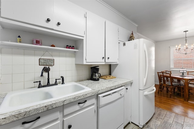 kitchen with decorative backsplash, light wood-type flooring, pendant lighting, sink, and white appliances