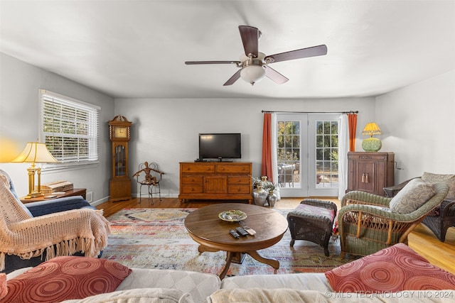 living room with french doors, light hardwood / wood-style floors, a wealth of natural light, and ceiling fan