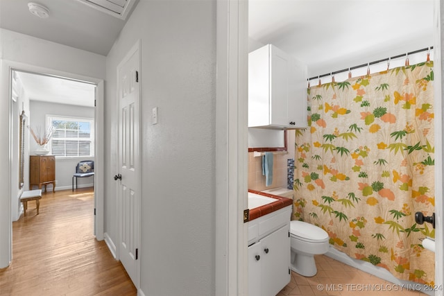 bathroom featuring toilet, hardwood / wood-style flooring, and vanity