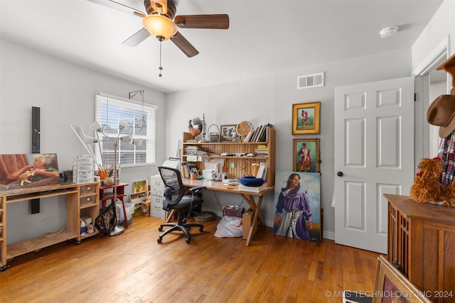 home office with light hardwood / wood-style floors and ceiling fan