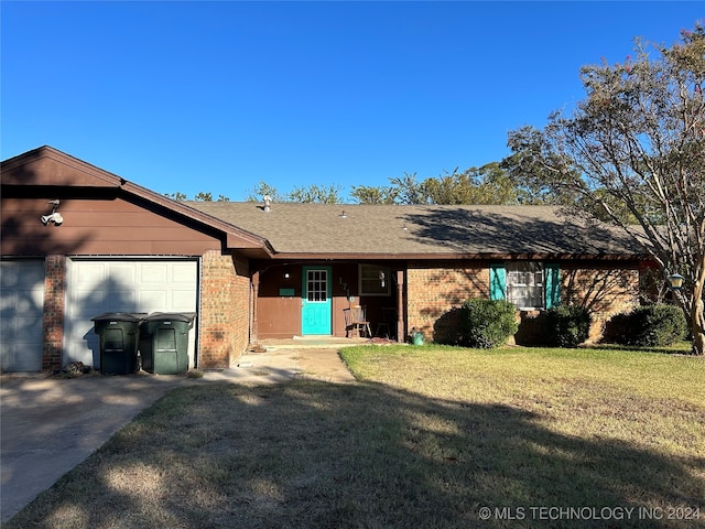 single story home featuring a garage and a front lawn