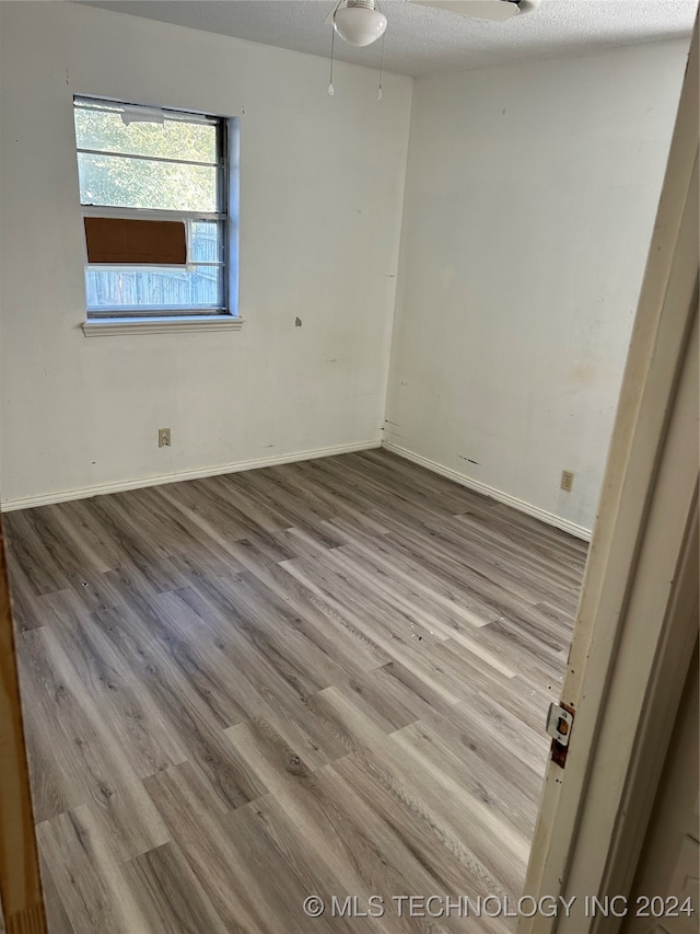 empty room featuring a textured ceiling and light hardwood / wood-style floors