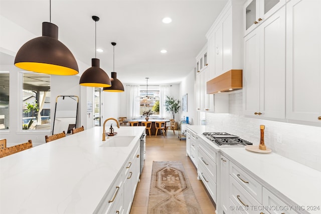 kitchen with stainless steel appliances, hanging light fixtures, decorative backsplash, and white cabinets