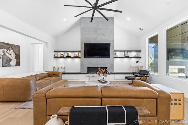 living room with light hardwood / wood-style floors, lofted ceiling, a fireplace, and ceiling fan