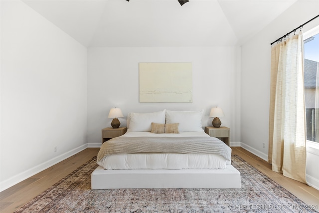 bedroom featuring hardwood / wood-style floors and vaulted ceiling