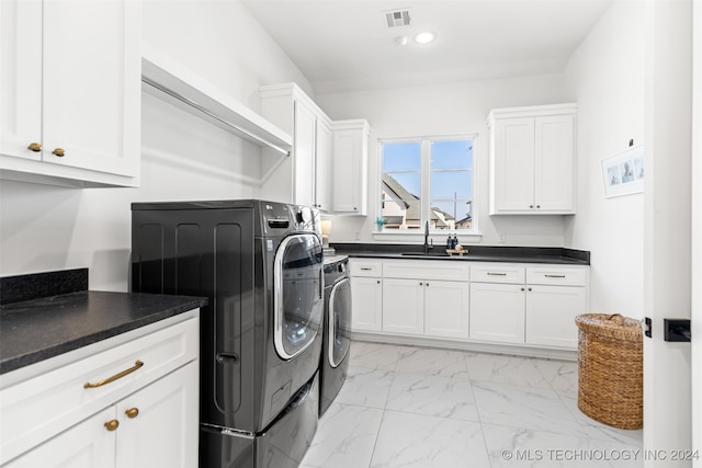 laundry area with cabinets, sink, and washer and clothes dryer