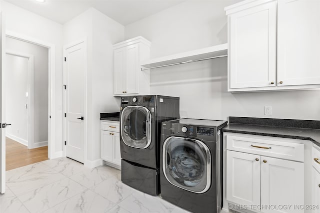 washroom featuring cabinets and washing machine and dryer