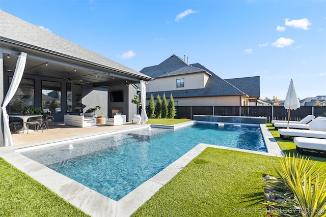 view of pool featuring a patio area, a yard, ceiling fan, pool water feature, and outdoor lounge area