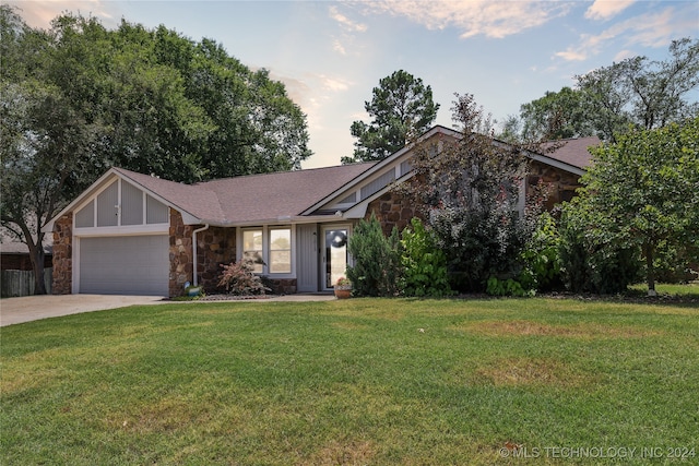 view of front of house featuring a garage and a lawn