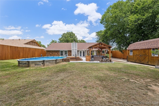 rear view of house with a gazebo, a patio area, a storage shed, and a yard