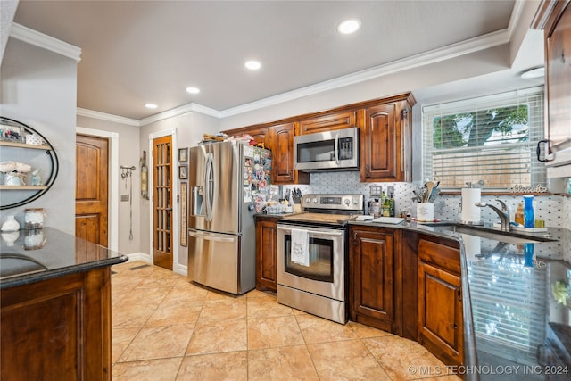 kitchen featuring light tile patterned flooring, stainless steel appliances, dark stone countertops, crown molding, and decorative backsplash